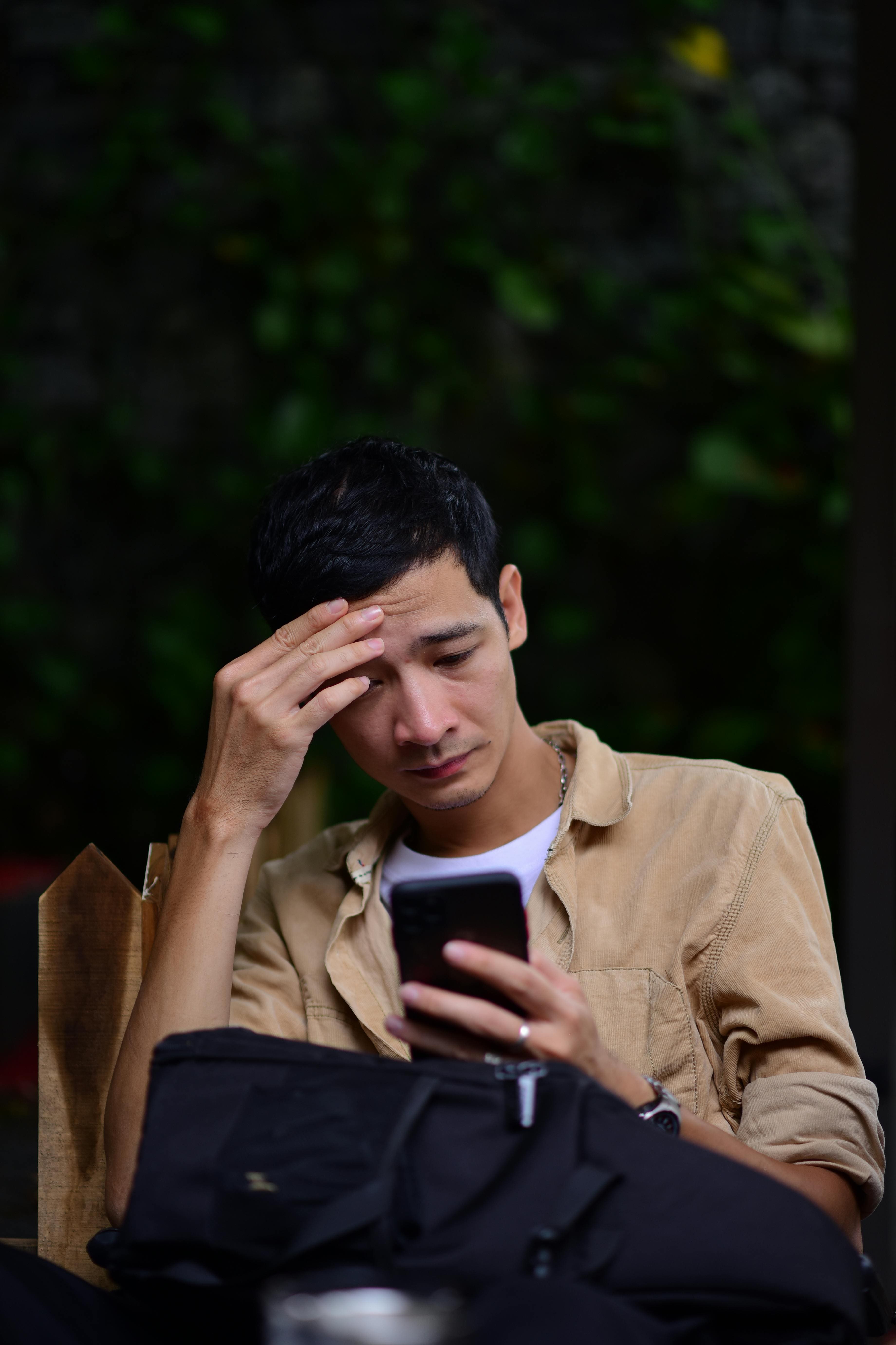 Persona joven usando el tel&eacute;fono en un entorno nocturno